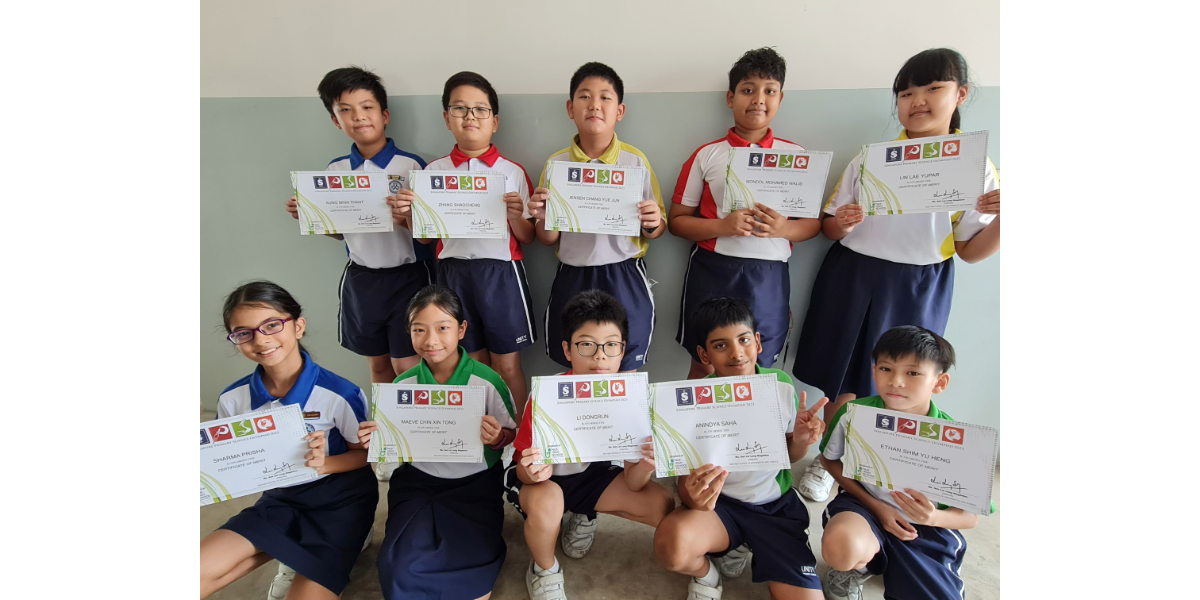 Ten school children in two rows smile while holding certificates, wearing colorful school uniforms.